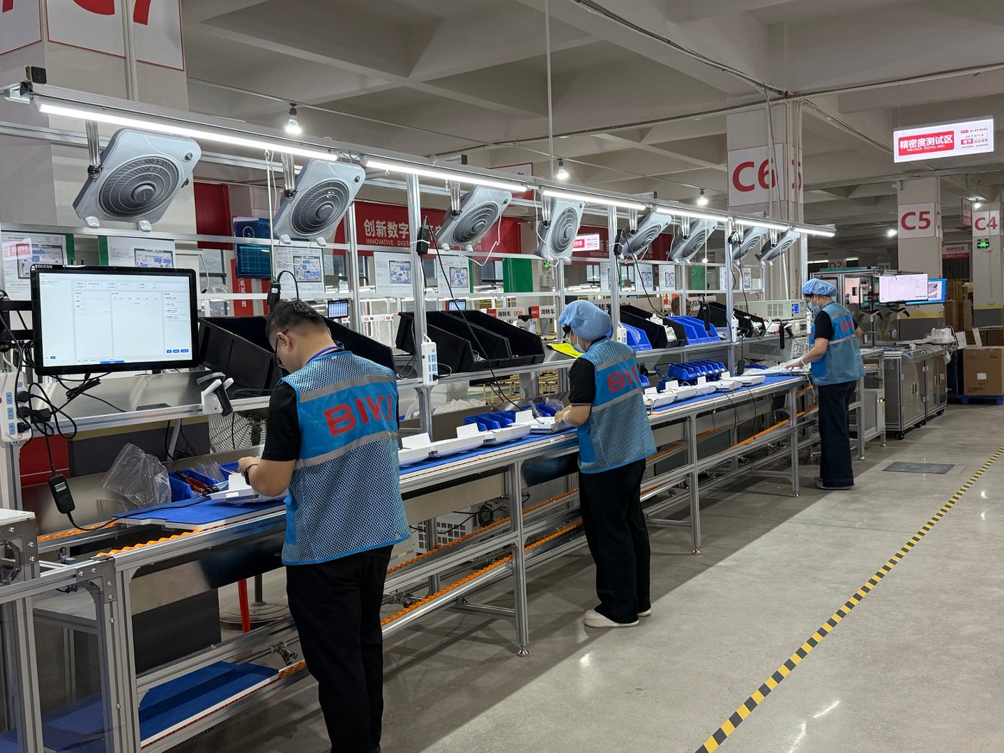 BIKI technicians assembling smart toilet components on a production line